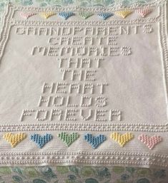 a white crocheted blanket with hearts on it