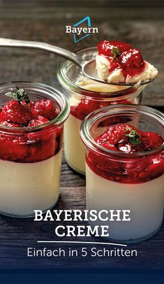 three jars filled with food sitting on top of a wooden table next to a spoon