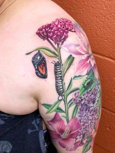 a woman with a butterfly and flower tattoo on her shoulder