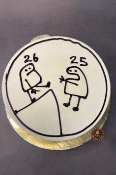 a white cake with black writing on it and a drawing of two people holding each other