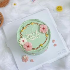 there is a green cake with flowers on the top and words above it that read, always be happy