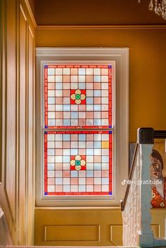 a stained glass window in the corner of a room with stairs leading up to it