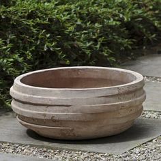 a cement bowl sitting on top of a stone walkway