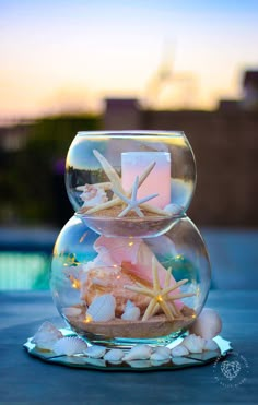 two fishbowes filled with sand and starfish are sitting on the table next to each other