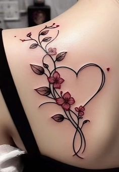 a woman's back with flowers and leaves on her shoulder, the tattoo is shaped like a heart