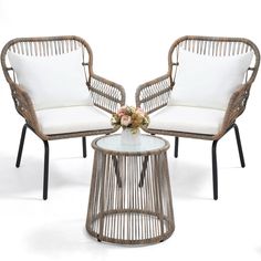 two chairs and a table with flowers on it in front of a white background the chair is made out of wicker