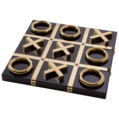 a black and gold tic - tac - toe board with rings on it