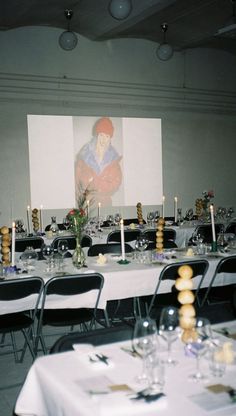 an image of a dining room setting with white tablecloths and candles on the tables