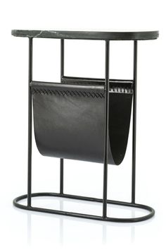 a black table with a magazine holder on it and a leather bag hanging from the top