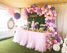 a pink and purple dessert table with balloons