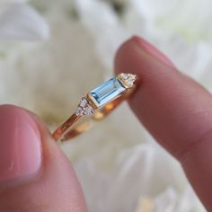 If you are looking for something delicate and simple but still perfect to stack with your other rings, look no further than our Malia ring. With a tapered Swiss Blue Topaz baguette and side moissanite, it is the perfect promise ring or as a gift for your loved one. Details: Center stone Gemstone: Swiss Blue Topaz Stone Shape: Baguette Measurements: approx. 6x3mm Side stones Gemstone: Moissanite Shape: Round Measurements: 1.3mm (6) Band measurements: approx. 1.8mm wide, approx. 1.5mm thick Pictur Topaz Rings, Black Spinel Ring, Swiss Blue Topaz Ring, Green Topaz, Indicolite Tourmaline, Baguette Ring, London Blue Topaz Ring, Gold Gemstone Ring, Blue Topaz Stone