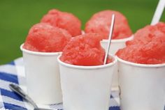 four cups filled with ice cream on top of a blue and white checkered table cloth