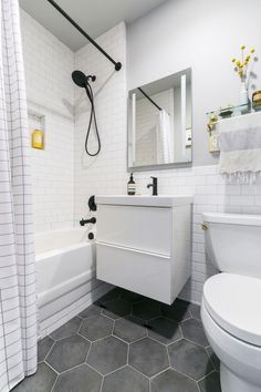 a bathroom with a toilet, sink, and bathtub in white tiled flooring