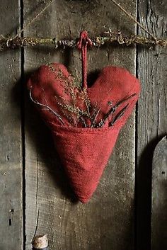 a red heart hanging on a wooden wall