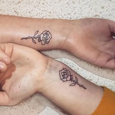 two people with matching tattoos on their feet, one holding the other's hand