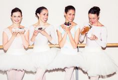 three ballerinas are eating donuts and posing for the camera