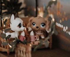 two little dolls sitting on top of a wooden table