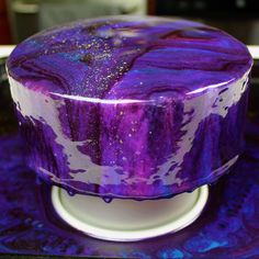 a purple and white cake sitting on top of a table