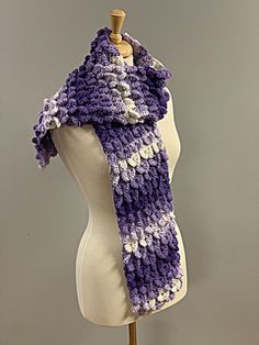 a purple and white knitted scarf on a mannequin