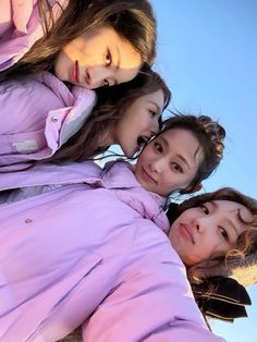 three girls are standing together and posing for the camera