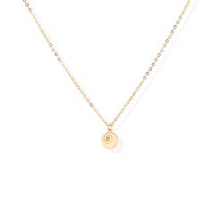 a gold necklace with an initial charm on it