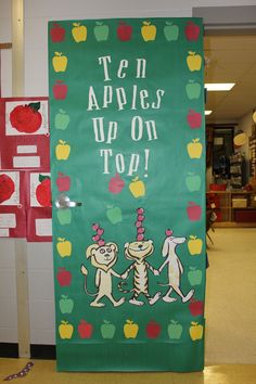 a classroom door decorated with apples and two monkeys holding hands in front of an apple top sign