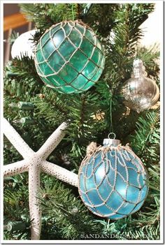 an ornament hanging from a christmas tree with starfishs and seashells