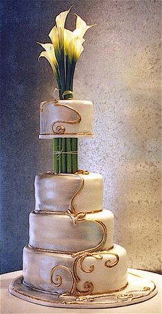 a three tiered wedding cake with flowers on top