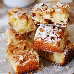 several pieces of cake are stacked on top of each other with powdered sugar around them