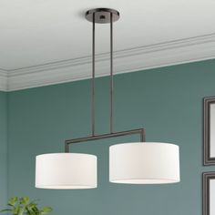 two lights hanging from the ceiling above a dining room table