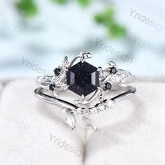 a black diamond ring sitting on top of an open book