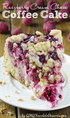 a close up of a piece of cake on a plate with raspberry topping