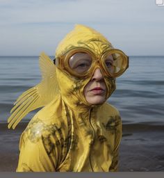 a woman in a yellow wet suit and goggles