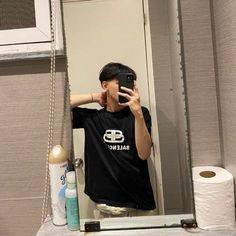 a man taking a selfie in front of a bathroom mirror