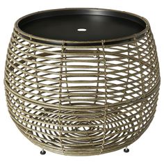 a round wicker table with glass top on casteors and wheels, isolated against a white background