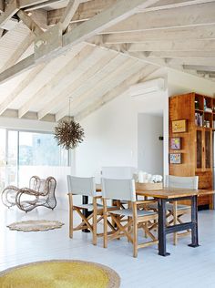 a dining room table and chairs in front of an open bookcase with sliding glass doors