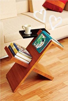 a wooden table with books on it and a cup sitting on top of the book shelf