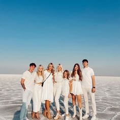 a group of people standing on top of a snow covered ground next to each other