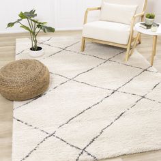 a living room with a chair, rug and potted plant