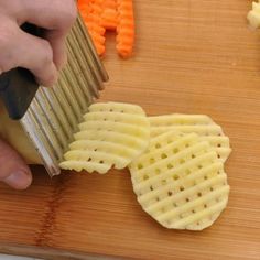 a person is cutting up some food on a wooden board with carrots and celery