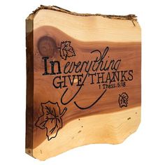 a wooden plaque with the words, in everything give thanks and leaves engraved on it