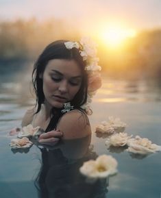 a woman in the water with flowers around her neck