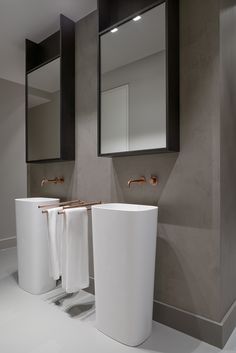 a bathroom with two sinks and three mirrors on the wall next to eachother