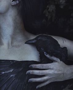 a woman holding a black bird in her hand with the words voge written on it