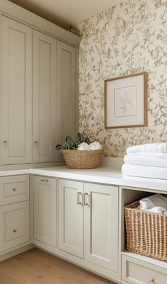 a bathroom with white cabinets and wall paper