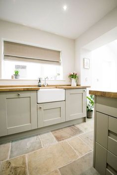 a kitchen with white cabinets and beige counter tops