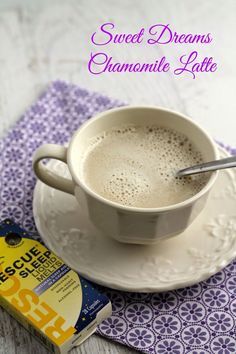 a cup of hot chocolate on a saucer next to a packet of sweet dreams chamole latte