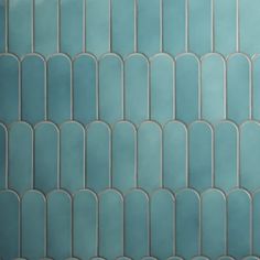 a blue tiled wall with curved lines on it