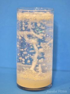 a clear glass filled with liquid on top of a blue table