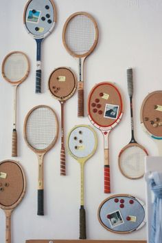 a bunch of tennis racquets are hanging on the wall